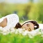 Mädchen schläft im Gras mit Blumen