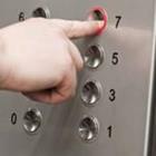 Eine Person, die auf Knopfdruck auf einem Aufzug