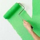 Ein Pinsel mit grüner Farbe auf der weißen Wand