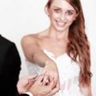 Eine Frau in einem weißen Kleid hält ihre Hand mit einem Ring auf ihn